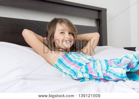 A Portrait of beautiful little girl lying on bed