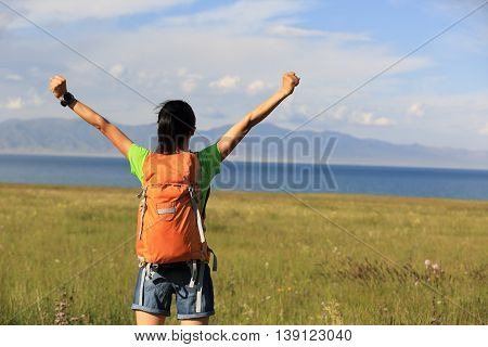 young woman hiker open arms to beautiful landscape