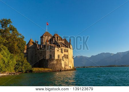 Beautiful view of Chillon castle at dusk in the golden sunshine on the lakeside of Lake Geneva Montreux Canton of Vaud Switzerland