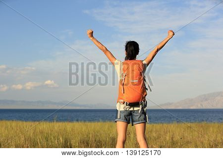 young woman hiker open arms to beautiful landscape