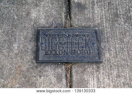 SHOREWOOD, ILLINOIS / UNITED STATES - AUGUST 30, 2015: A bronze plaque, attached to the sidewalk, indicates that the benches and swings along Shorewood's riverfront were donated by Exxon Mobil.