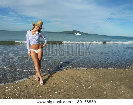 Smiley New Zealand girl on the beach in Auckland. Takapuna beach and Rangitoto island in background.