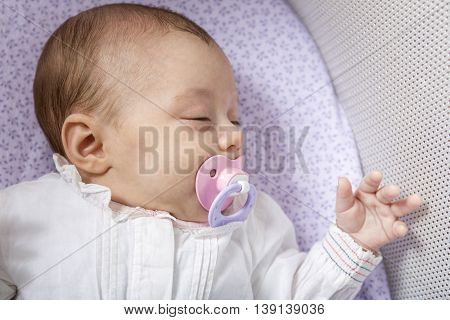 A Baby sleep in a small cradle