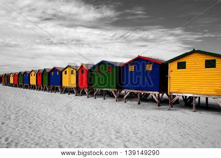 The row of wooden brightly colored huts on Sunrise Beach. Atlantic ocean. Cape Town. Muizenberg. South Africa. Modern architecture art.
