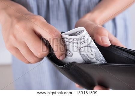 hands show money dollar bills in black wallet. business finance concept