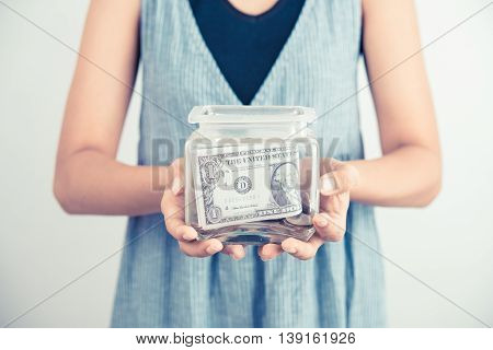 hands holding piggy bank show money dollar bills and coin in piggy bank. business savings finance concept