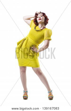 Young beautiful red-haired caucasian woman in yellow dress posing in studio isolated on white background professional makeup and hairstyle full-length portrait