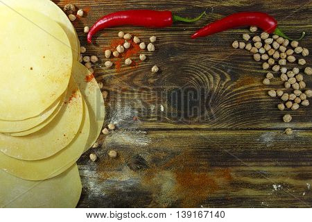 Colorful Indian food - papadum chickpea gram flour and spices on textured wooden table top