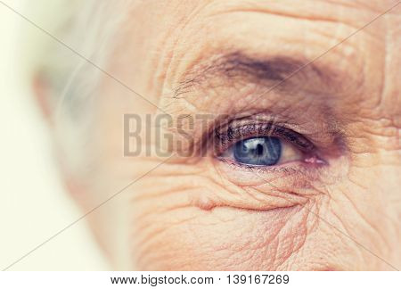 age, vision and old people concept - close up of senior woman face and eye