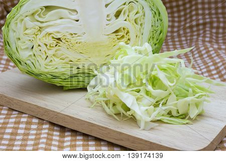 Closeup cabbage and cutted cabbage on wooden fabric scott pattern background