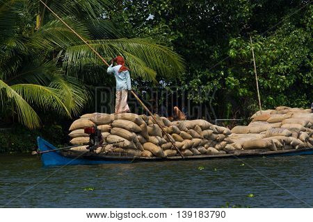 Allepey, Kerala, India March 31, 2015: Indian man transport dwell with rice for boats. backwaters canoe in state, . Cochin
