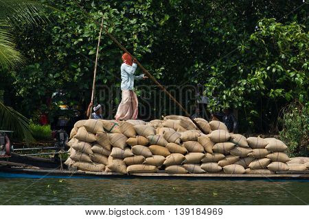 Allepey, Kerala, India March 31, 2015: Indian man transport dwell with rice for boats. backwaters canoe in state, . Cochin
