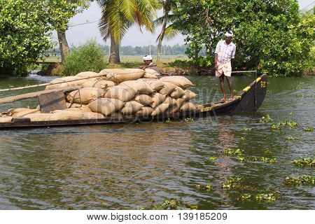 Allepey, Kerala, India, March 31, 2015: Indian man transport dwell on boats. Backwaters canoe