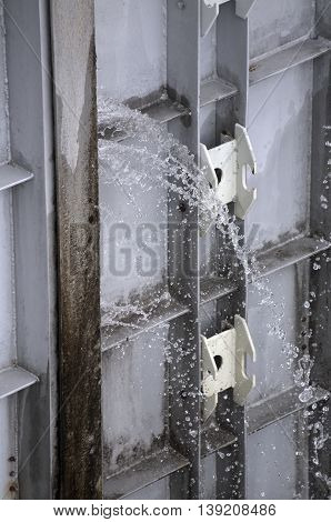 Water spraying through a leaky watergate .