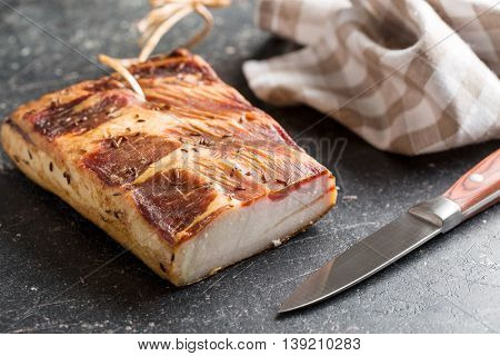 Fresh smooked bacon on old kitchen table.