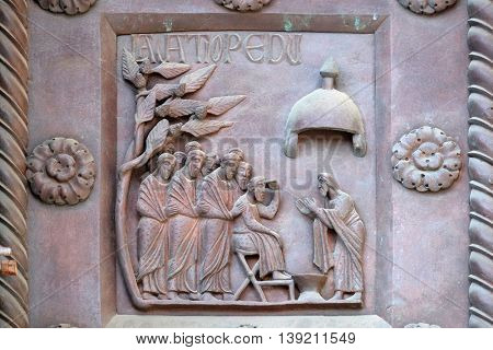 PISA, ITALY - JUNE 06, 2015: Washing of the Feet on the San Ranieri gate of the Cathedral St. Mary of the Assumption in Pisa, Italy on June 06, 2015