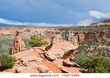 A tourist enjoying a spectacular view from Grand View in Colorado National Monument