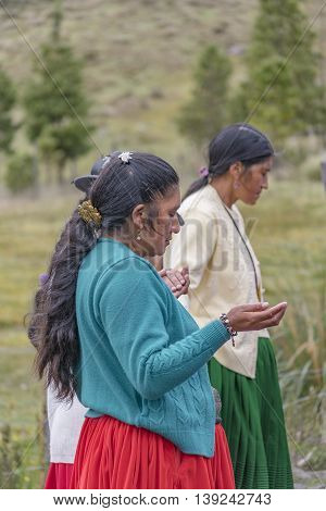 CUENCA, ECUADOR, OCTOBER - 2015 - Group of native ecuadorian catholic indigenous women praying at outdoors in Cuenca outskirts Ecuador South America