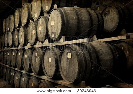 Wine barrels stacked in the old cellar of the winery.