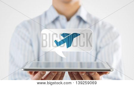 Businessman holding tablet with travel icon on screen