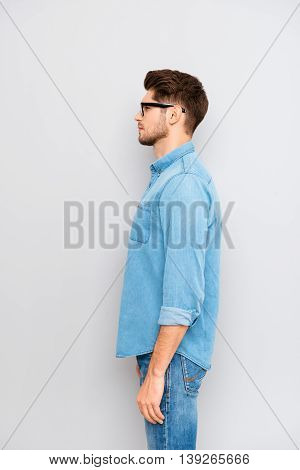 Side View Portrait Of Young Guy In Glasses And Blue Shirt