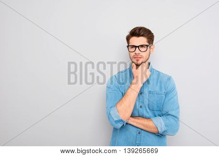 Portrait Of Handsome Minded Young Man In Glasses Think