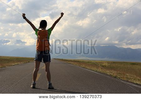 young woman hiker open arms at beautiful mountain trail