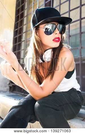 A beautiful young Hip Hop Rapper girl with Headphones in a urban environment.