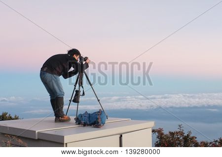 Ranau,Sabah,Malaysia-March 12,2016:Silhouette of a photographer framing a shot, taking pictures at beautiful sunset on Laban Rata.This place is for climbers to rest before summiting the mount peak.