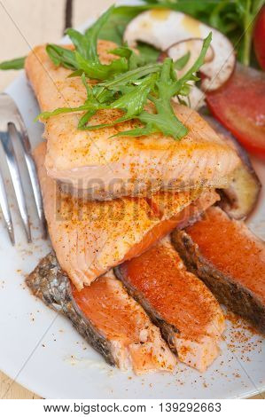 close up image of grilled samon filet with vegetables salad