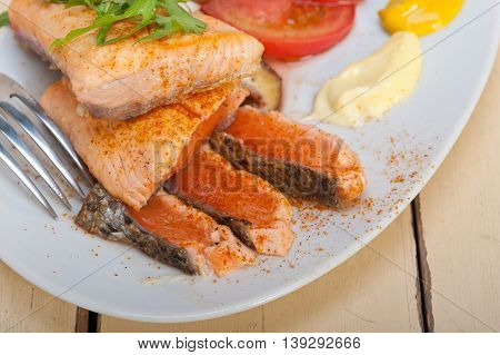 close up image of grilled samon filet with vegetables salad