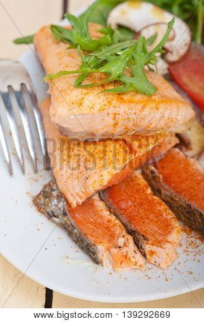 close up image of grilled samon filet with vegetables salad