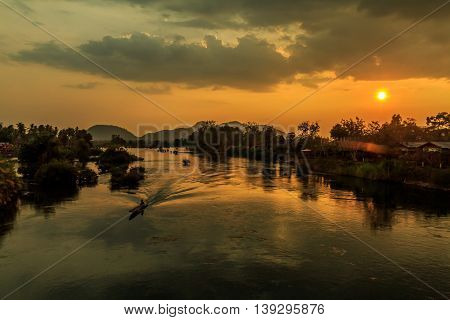 A longboat on the Mekong River as the sun sets in Laos