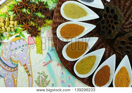 Colorful variety of Indian spices on traditional ornamental background