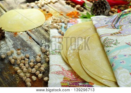 Colorful Indian food - papadum chickpea gram flour and spices on textured wooden table top