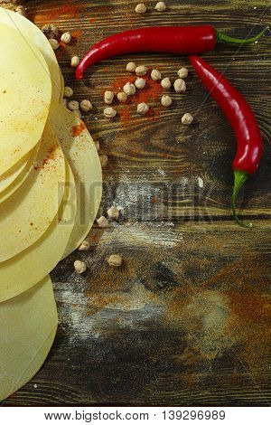 Colorful Indian food - papadum chickpea gram flour and spices on textured wooden table top