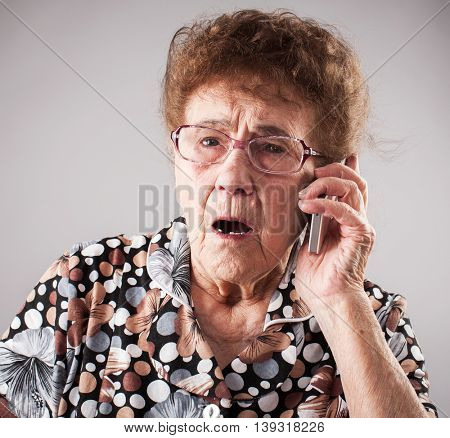 Surprised seniors talking mobile phone. Old adult mature woman. Shock