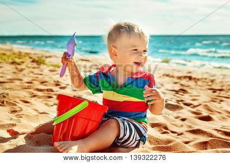 one year old boy smiling at the beach. Child on vacations at sea