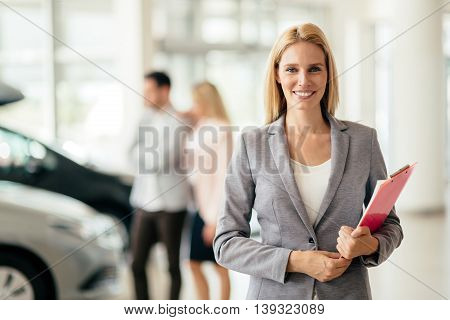 Elegant eautiful salesperson working at car dealership