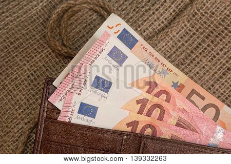 Euro banknotes in a purse on the textile background