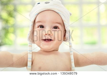Smiling happy baby with cute hat, close up