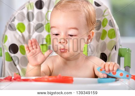 Happy adorable baby eating watermalon, close up