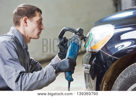 auto mechanic buffing and polishing car headlight