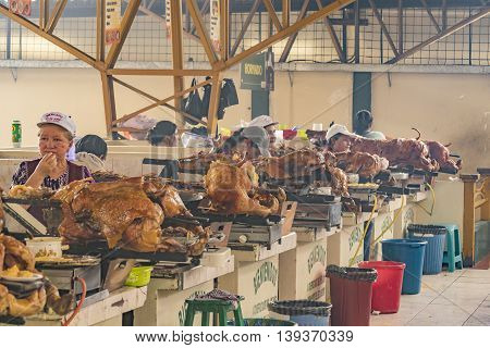 AZUAY, ECUADOR, OCTOBER - 2015 - Traditional women cooks showing his baked porks at interior popular food court in Azuay Ecuador.