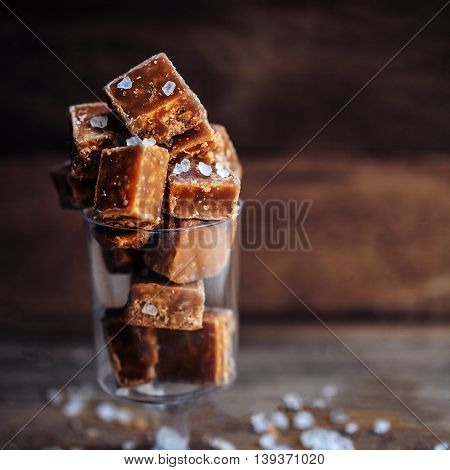 Sweet caramel candies. Salted caramel pieces and sea salt close up.