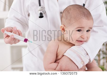 Baby receiving vaccine in lab, close up