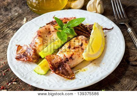 Grilled Squid With Lemon And Zucchini On Wooden Background
