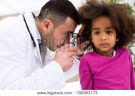 Pediatrician using otoscope ear examining at clinic