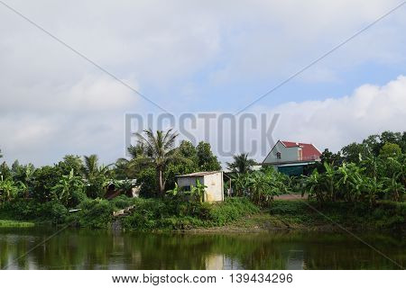 Vietnamese countryside with house next to the fishing pond