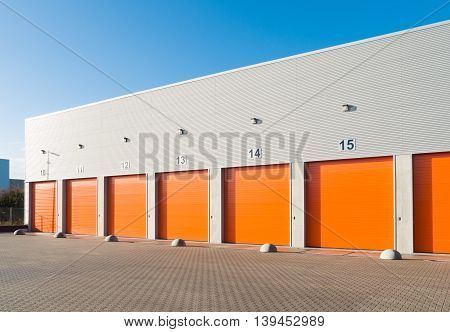 ENSCHEDE, NETHERLANDS - NOVEMBER 28, 2015: Exterior of a commercial warehouse with orange roller doors